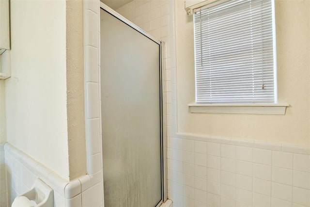 bathroom with tile walls and walk in shower