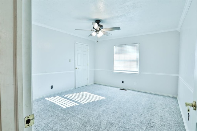 carpeted spare room with crown molding and ceiling fan