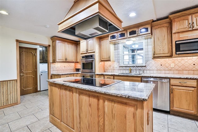 kitchen featuring sink, light stone countertops, appliances with stainless steel finishes, a kitchen island, and custom range hood