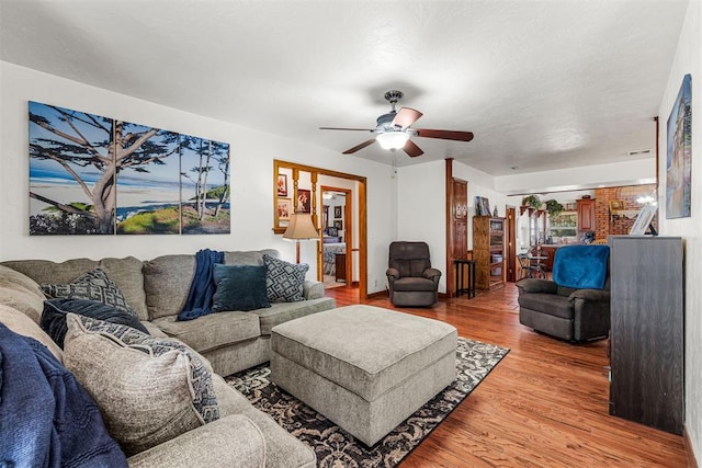 living room with wood-type flooring and ceiling fan