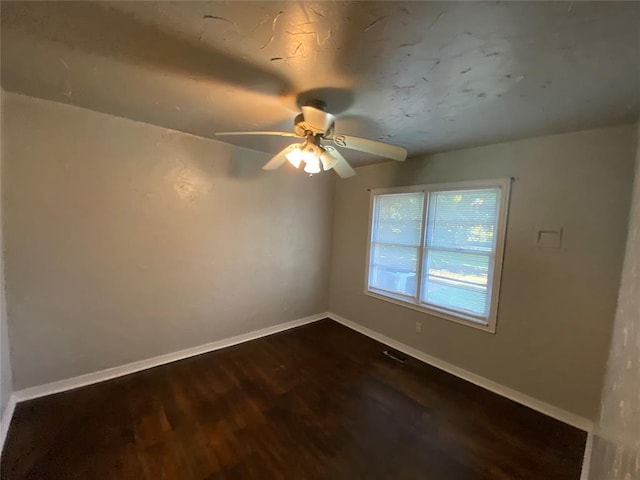 spare room featuring ceiling fan and dark hardwood / wood-style flooring