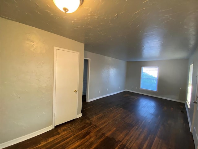 empty room with dark wood-type flooring