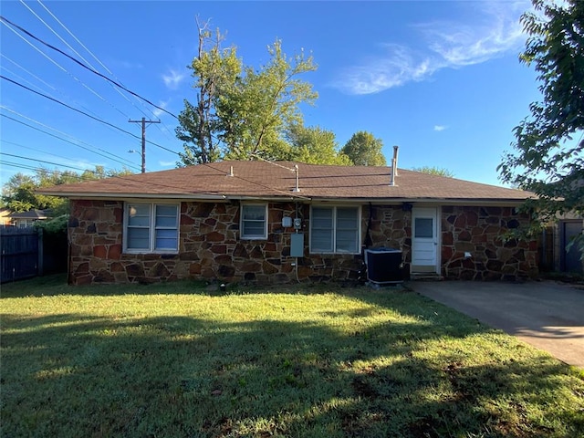 ranch-style house with central AC unit and a front lawn