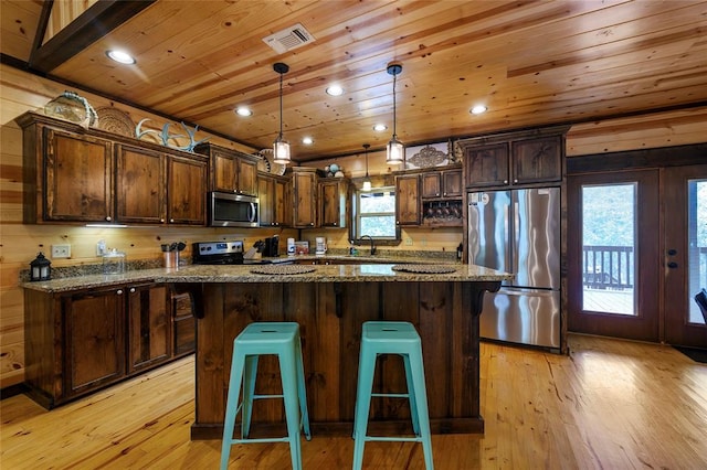 kitchen with a healthy amount of sunlight, dark stone countertops, and appliances with stainless steel finishes