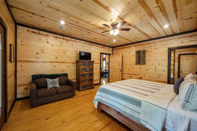 bedroom with ceiling fan, light wood-type flooring, wood ceiling, and wood walls