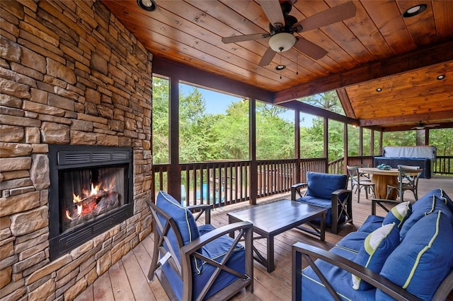 deck featuring an outdoor living space with a fireplace, ceiling fan, and exterior bar