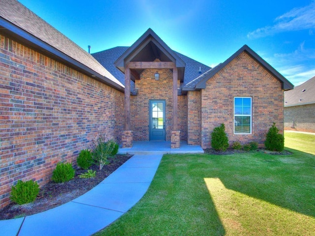 view of exterior entry with a yard