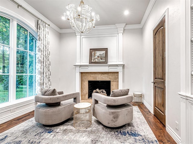 sitting room with a chandelier, ornamental molding, plenty of natural light, and dark wood-type flooring