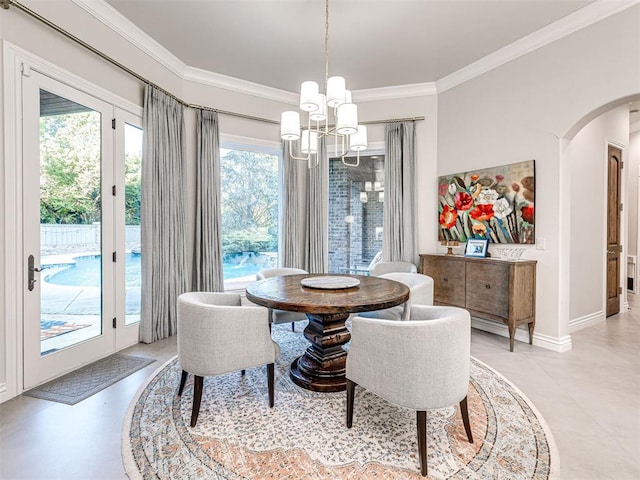 dining room featuring plenty of natural light, ornamental molding, and a chandelier