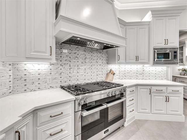 kitchen with white cabinets, custom range hood, backsplash, and stainless steel appliances