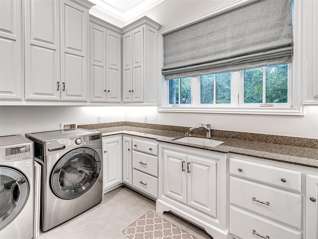 laundry room with crown molding, cabinets, sink, and washing machine and dryer