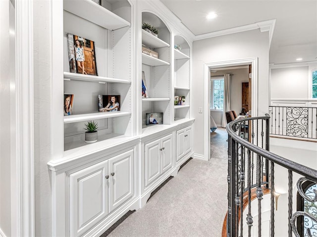 hallway with light colored carpet and crown molding