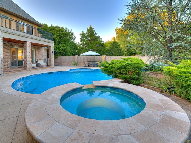 view of pool with an in ground hot tub and a patio area