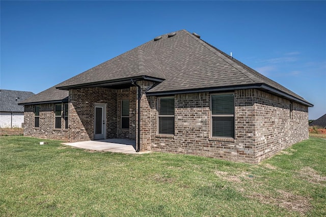 rear view of property with a yard and a patio