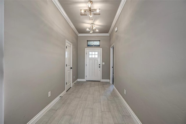 doorway featuring crown molding, a towering ceiling, light wood-type flooring, and a notable chandelier