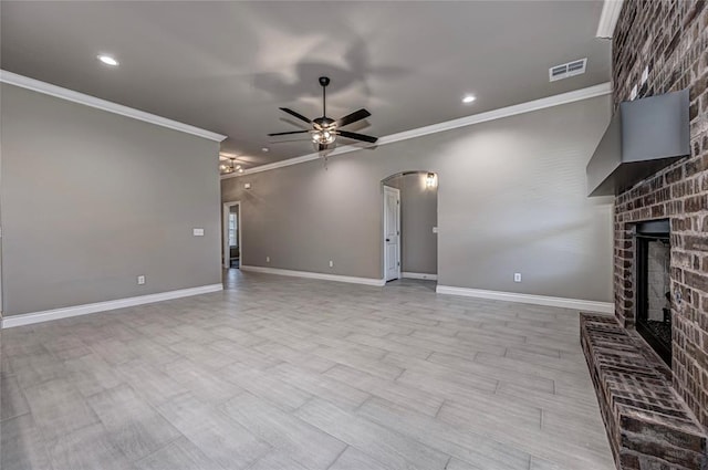 unfurnished living room featuring a brick fireplace, ceiling fan, and ornamental molding