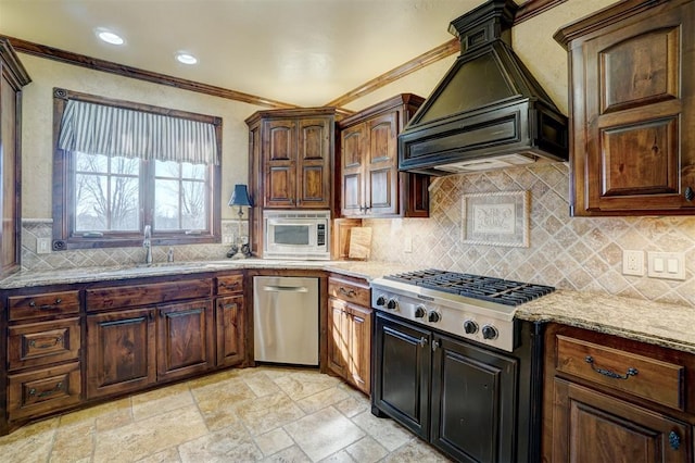 kitchen with tasteful backsplash, light stone counters, premium range hood, appliances with stainless steel finishes, and ornamental molding