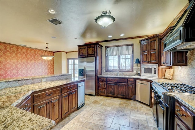 kitchen with premium range hood, decorative backsplash, light stone countertops, decorative light fixtures, and stainless steel appliances