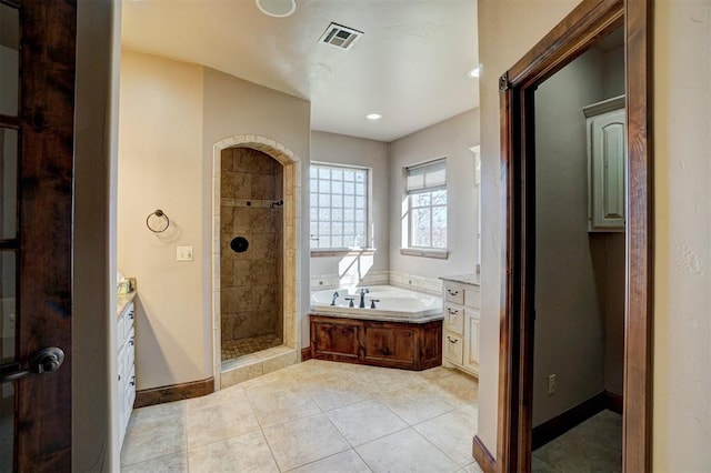 bathroom with tile patterned flooring, vanity, and plus walk in shower