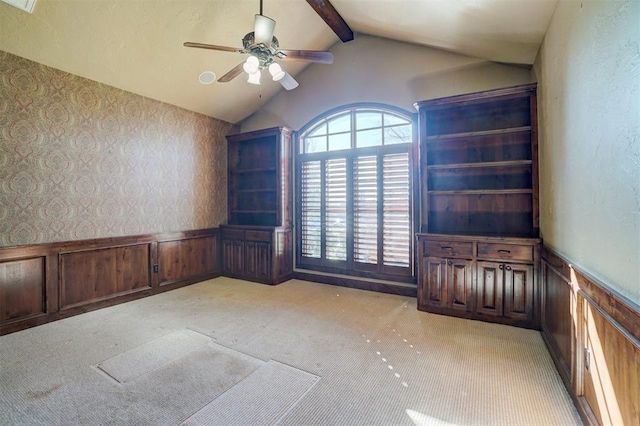 unfurnished room with vaulted ceiling with beams, ceiling fan, and light carpet