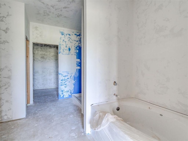 bathroom featuring concrete floors and a bathing tub