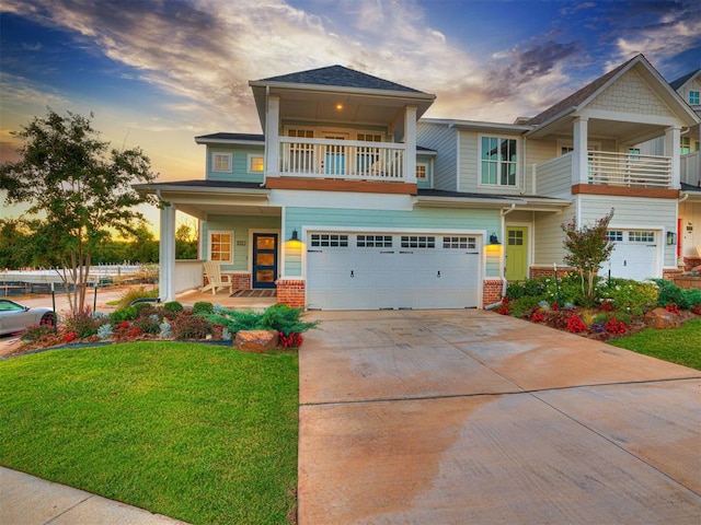 craftsman-style home with a yard, a balcony, a porch, and a garage