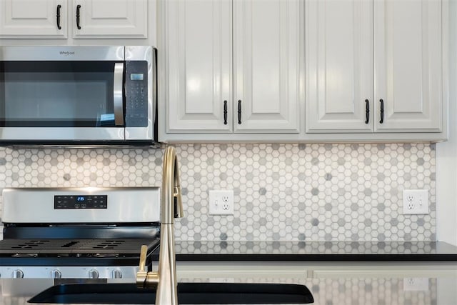 kitchen with tasteful backsplash, white cabinetry, and appliances with stainless steel finishes