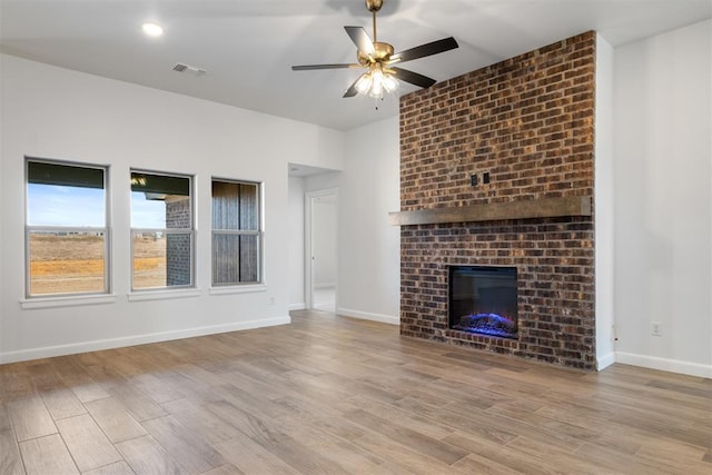 unfurnished living room with a fireplace, light hardwood / wood-style flooring, and ceiling fan