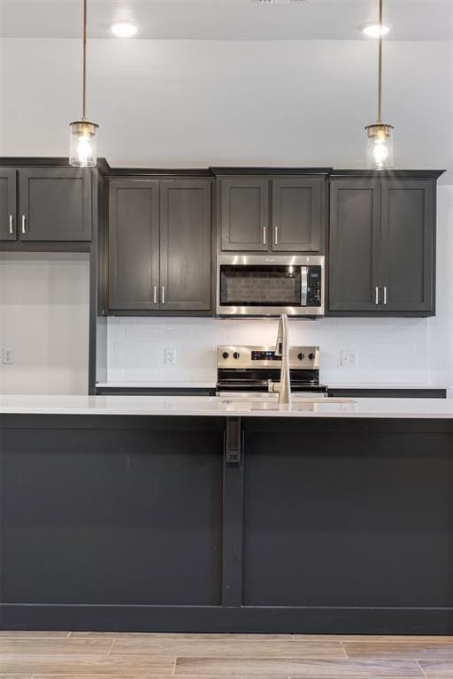 kitchen with decorative light fixtures, stainless steel appliances, and sink