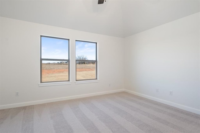 spare room featuring ceiling fan and light carpet