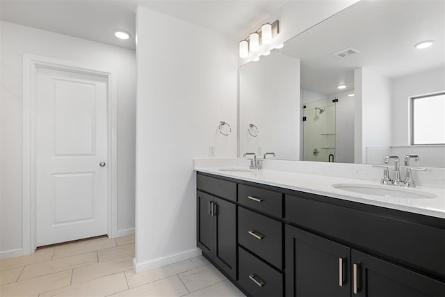 bathroom with vanity and a shower with door