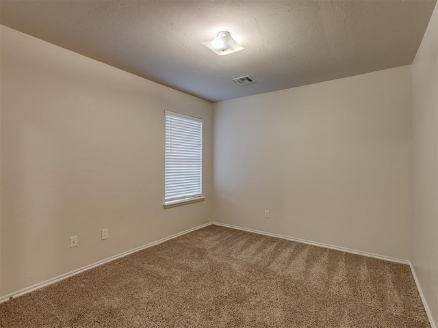 carpeted spare room with a textured ceiling