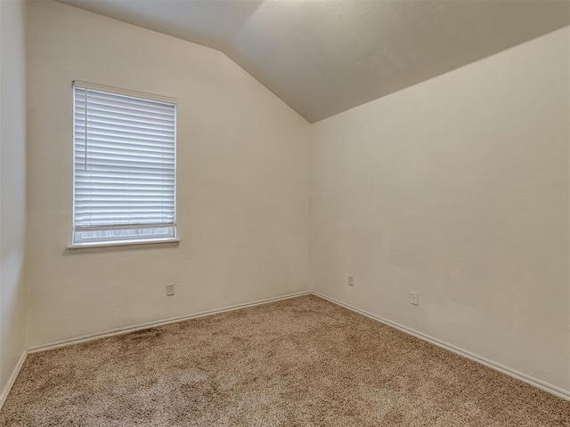 carpeted spare room featuring lofted ceiling