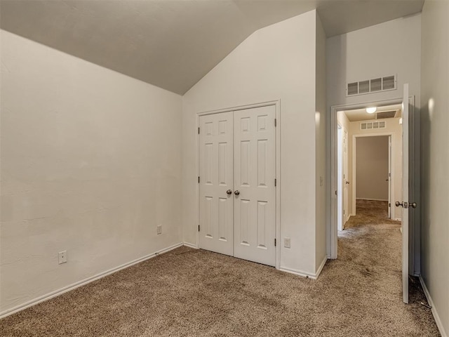 unfurnished bedroom with carpet, high vaulted ceiling, and a closet