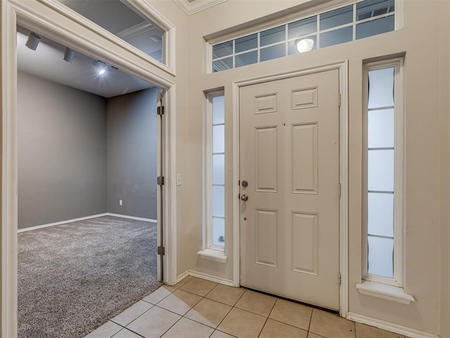 entrance foyer featuring crown molding, plenty of natural light, and light colored carpet