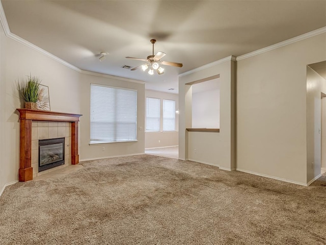 unfurnished living room featuring ceiling fan, ornamental molding, carpet floors, and a tiled fireplace