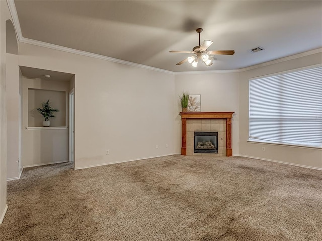 unfurnished living room featuring ceiling fan, a fireplace, carpet floors, and crown molding