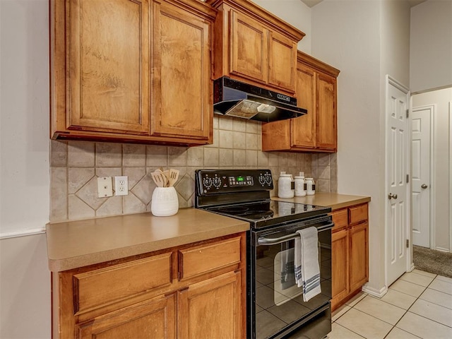 kitchen with black / electric stove, decorative backsplash, and light tile patterned flooring