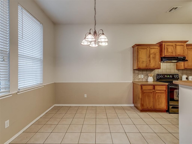 kitchen with hanging light fixtures, an inviting chandelier, black range with electric cooktop, decorative backsplash, and light tile patterned flooring