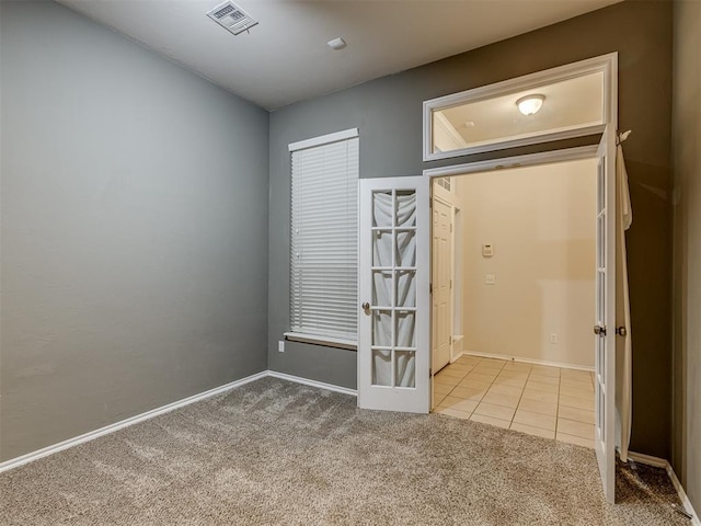 unfurnished room featuring light carpet