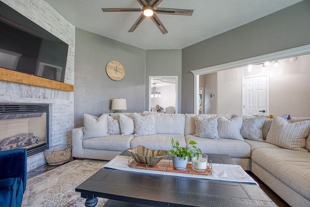 living room featuring ceiling fan and a brick fireplace