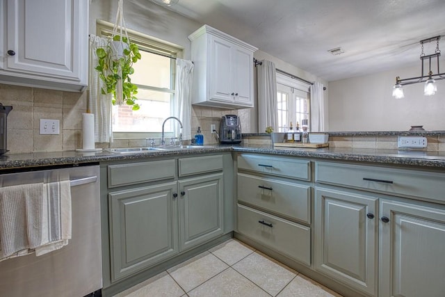 kitchen with tasteful backsplash, a wealth of natural light, dishwasher, and light tile patterned flooring