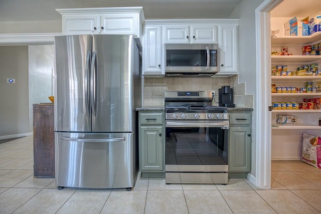 kitchen featuring decorative backsplash, white cabinets, light tile patterned flooring, and appliances with stainless steel finishes