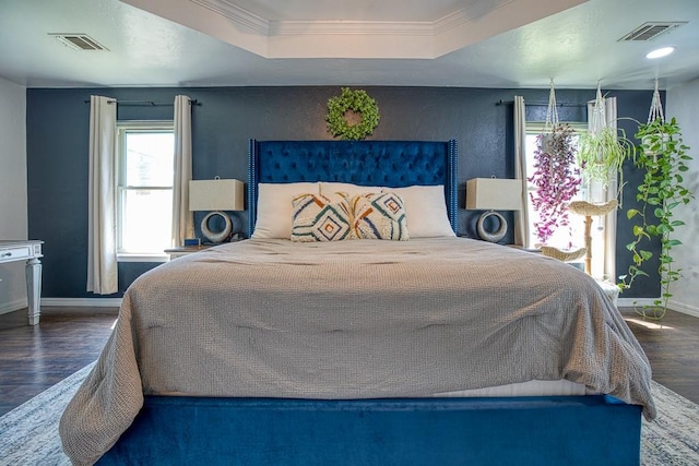 bedroom featuring a raised ceiling, crown molding, and dark hardwood / wood-style floors