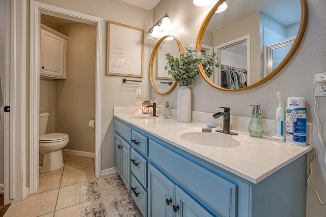 bathroom featuring tile patterned flooring, vanity, and toilet