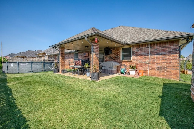 back of house with a yard and a patio