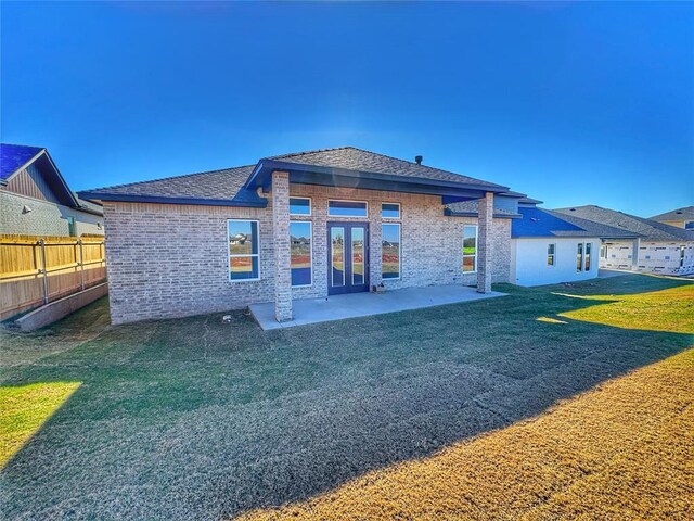 rear view of property featuring a lawn and a patio