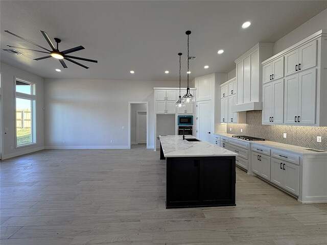 kitchen with white cabinets, a spacious island, decorative light fixtures, and appliances with stainless steel finishes