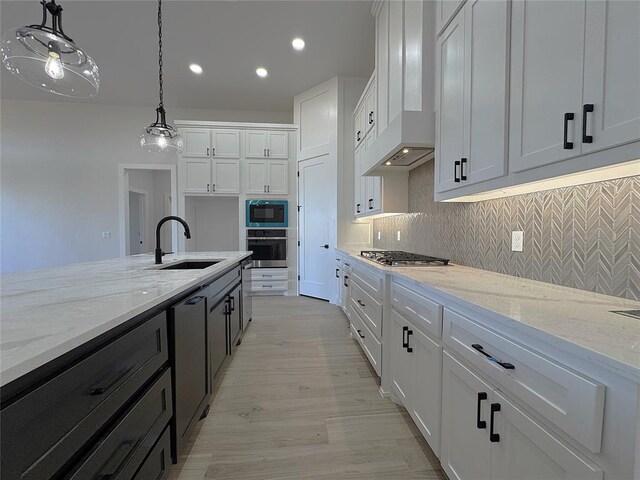 kitchen featuring pendant lighting, white cabinetry, appliances with stainless steel finishes, and sink