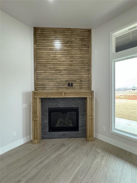 details featuring wood-type flooring and a tiled fireplace